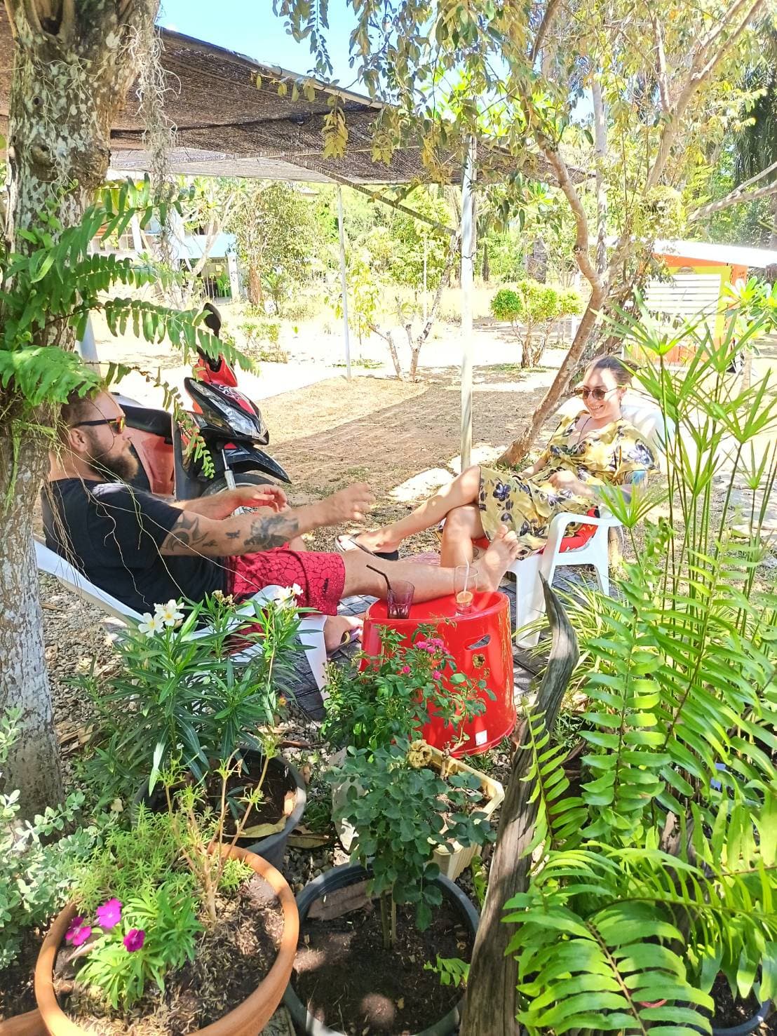 Guests relaxing in the peaceful garden outdoor seating area at MaeKung Cafe Krabi