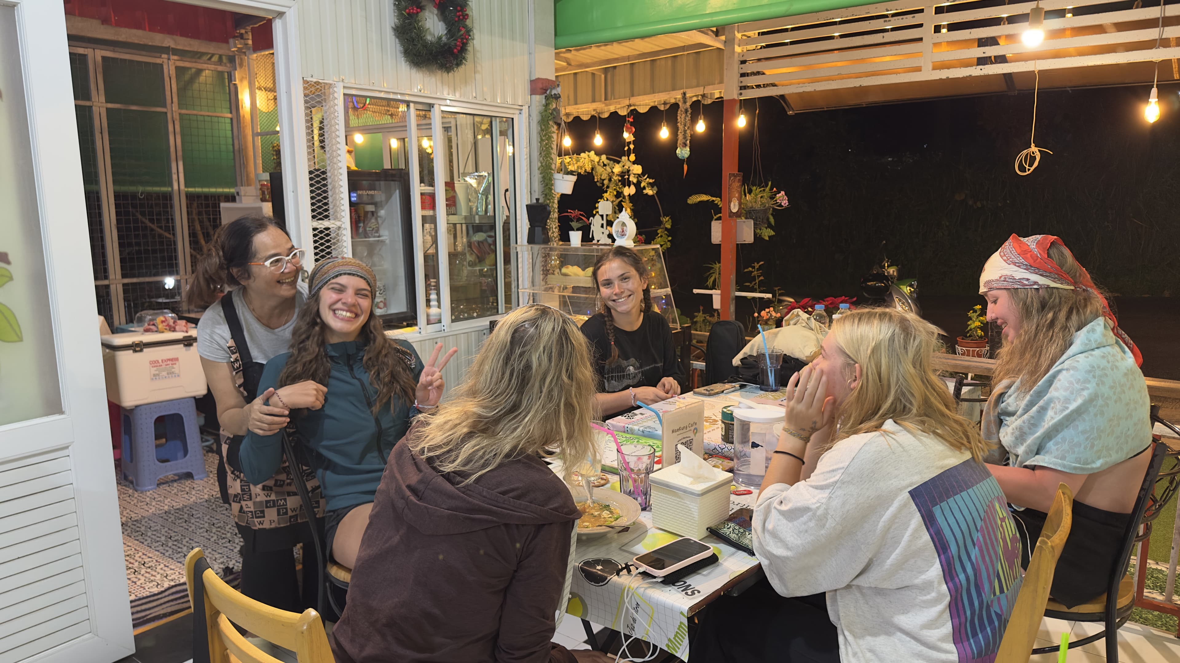 Group of friends laughing and enjoying the night atmosphere at MaeKung Cafe Krabi