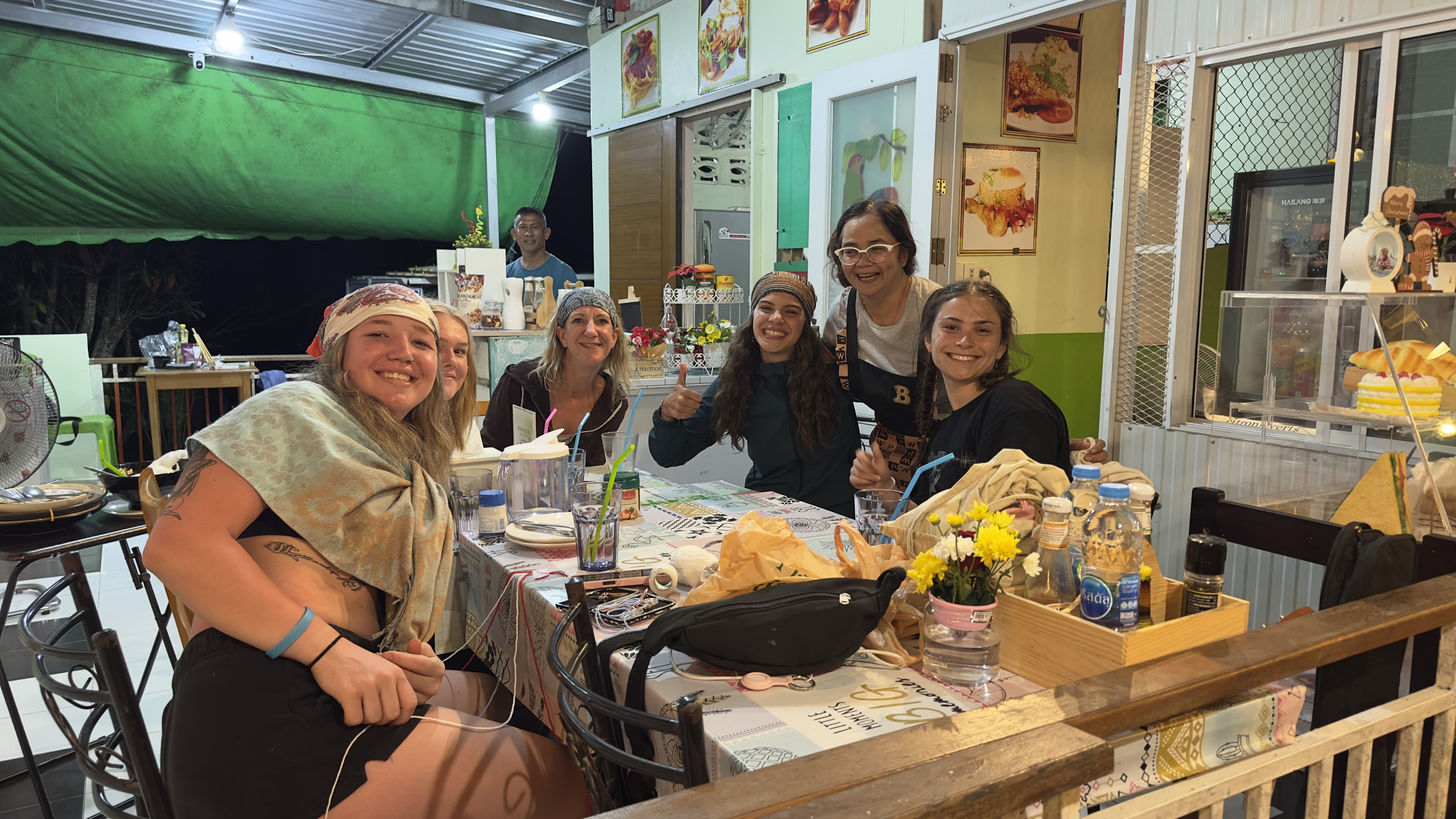 Group of international travelers sharing dinner at night at MaeKung Cafe Krabi